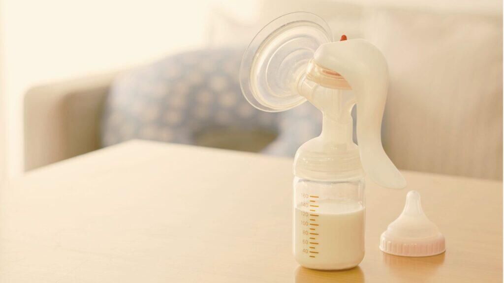 Sacaleches manual con leche materna extraída para ofrecer al bebé durante el día o la noche